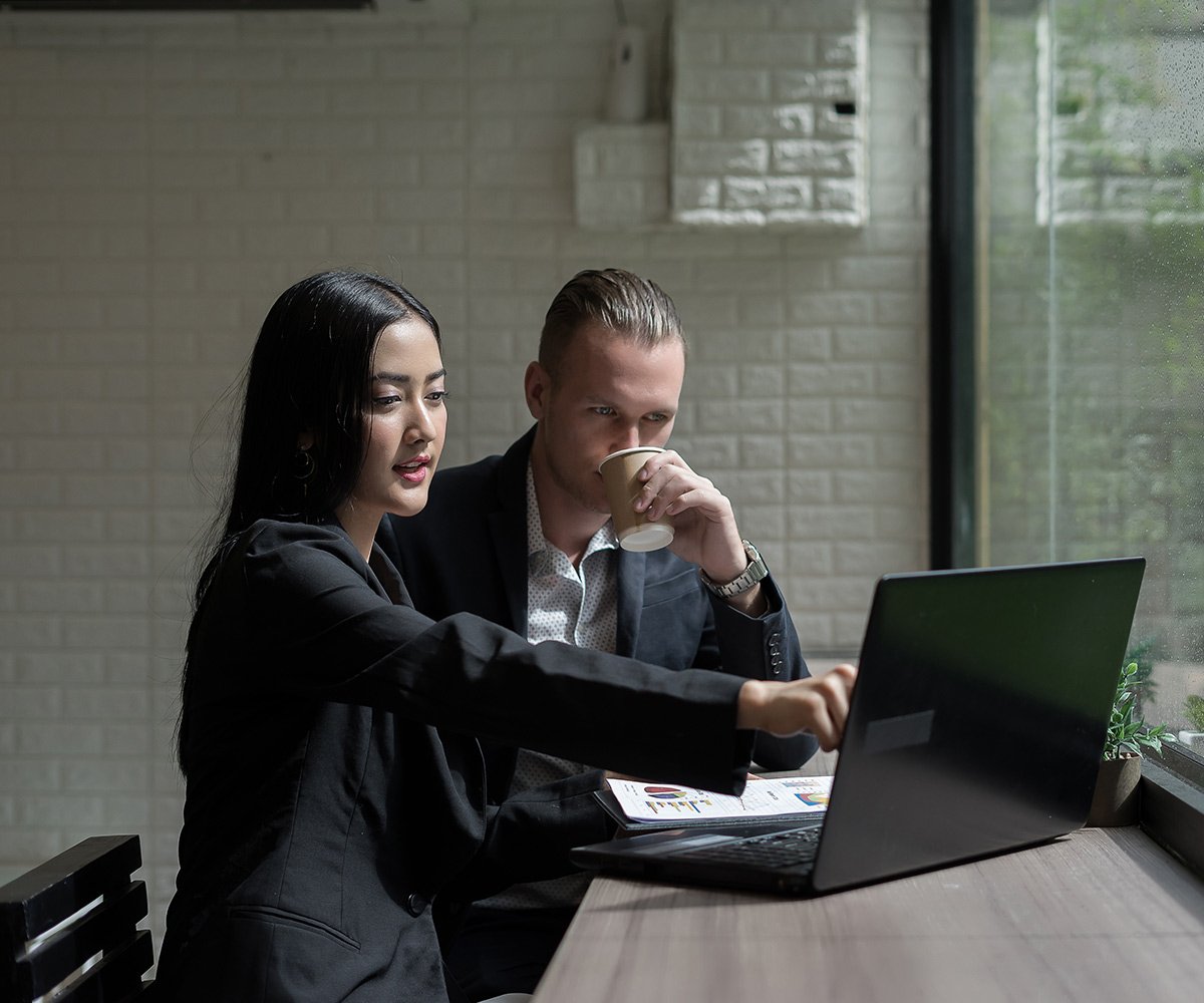 young-business-woman-showing-something-to-mature-b-A9QPQQN